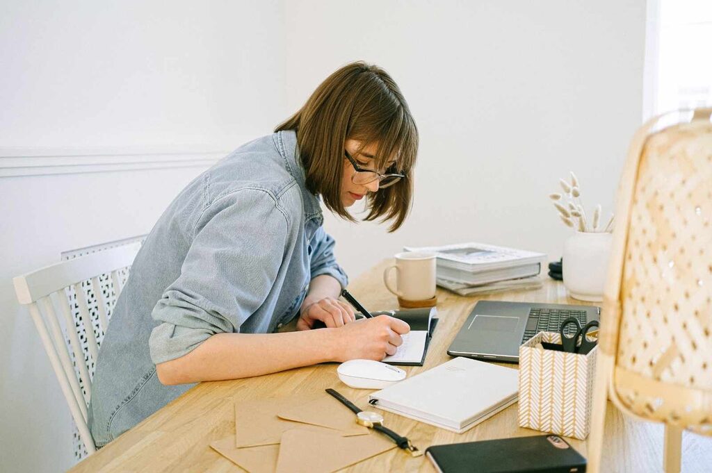 Young woman writing on a notebook the results of her research to discover if blogging is still relevant in 2026