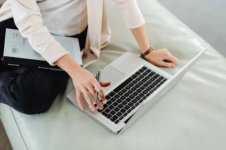Woman's hands typing on a laptop. The image illustrates the article "how to start a blog with no experience."