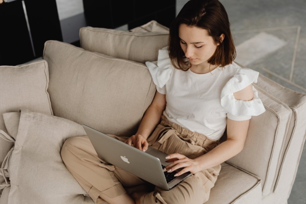 Young brunette woman typing on a laptop.