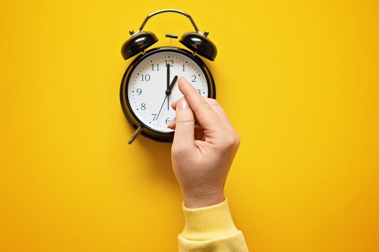 Analog clock on a yellow background with a hand pointing to the numbers.