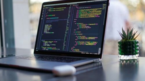 Programmer working on a laptop exploring side hustles to earn extra income in 2025, checking the 9 best programming side hustles.