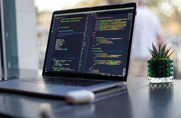 Programmer working on a laptop exploring side hustles to earn extra income in 2025, checking the 9 best programming side hustles.
