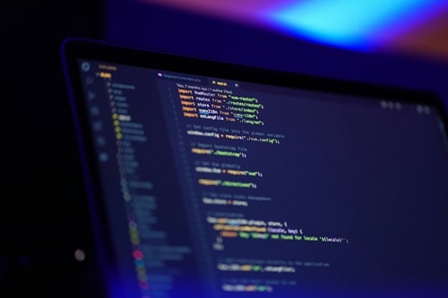 A laptop screen shows some coding in progress, illustrating how to make passive income as a web developer