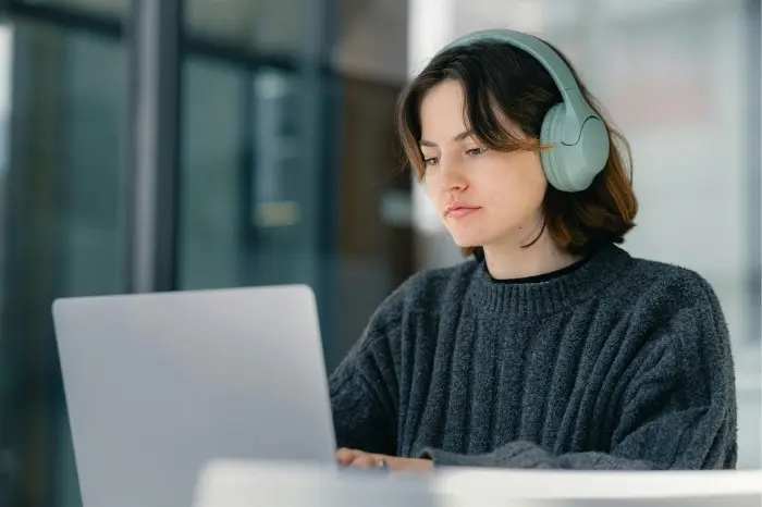 Woman works on her laptop. She's comparing features, pricing, and benefits of the best affordable email service providers for small business owners.