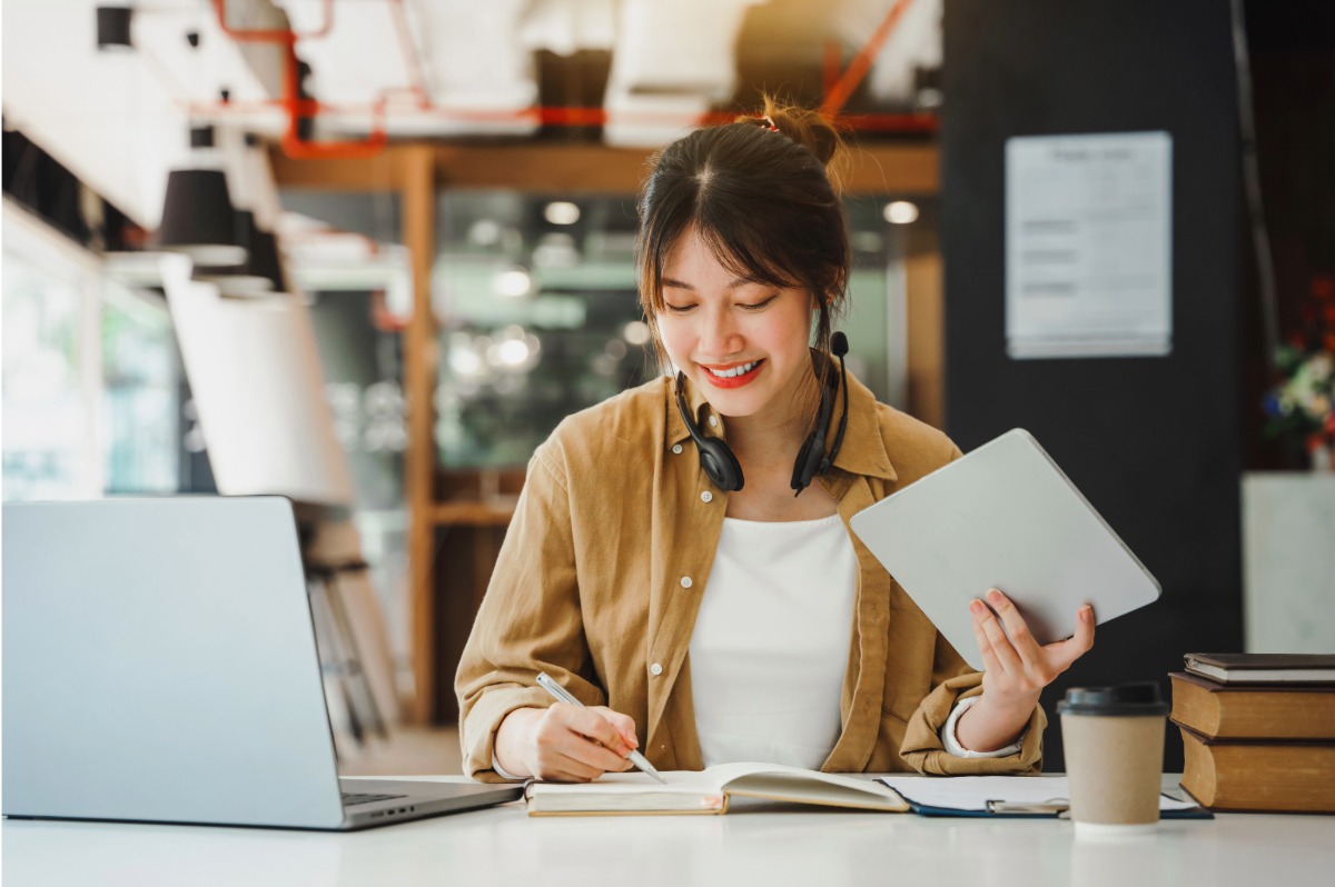Young Asian woman working. The image illustrates the subject: "How Entrepreneurs Can Use Adobe Express to Build Smarter Marketing."