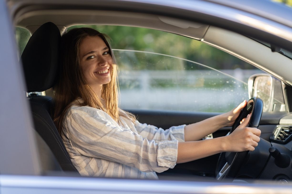 Young female driver smiling. The image illustrates the subject: "Why Custom Car Accessories Are a Profitable Print-on-Demand Niche"