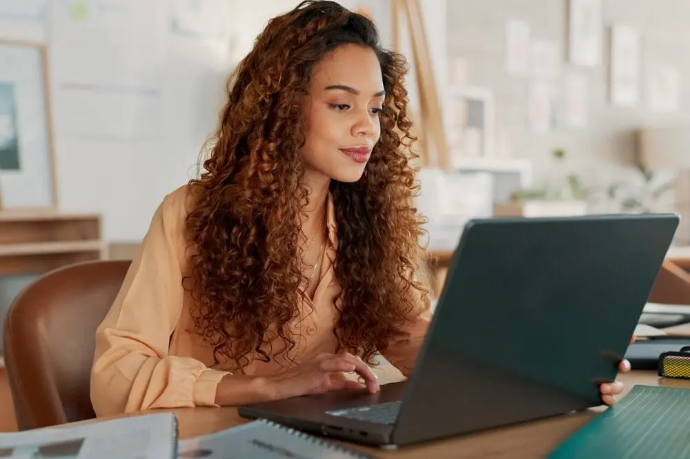 Concentrated and busy-looking woman working with a laptop.