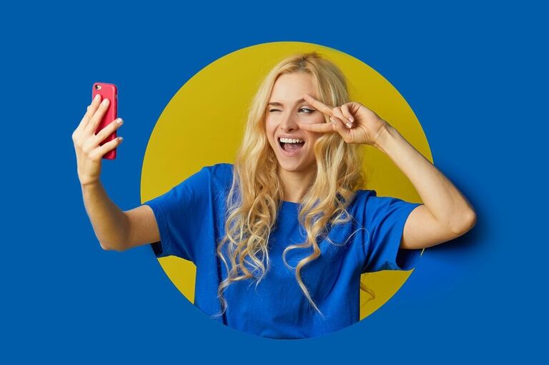 Content creator taking a selfie on a colorful background.